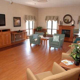 A cozy living room with armchairs, a fireplace, and a television.