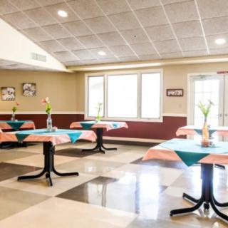 A bright and spacious dining area with neatly arranged tables and chairs.