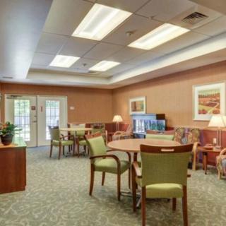 A spacious and well-lit room with multiple seating arrangements and tasteful decor.