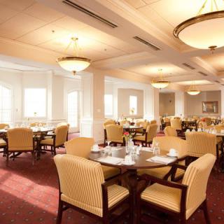 A spacious and elegant dining room with neatly arranged tables and chairs.