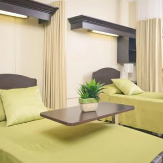 A hospital room with two beds separated by curtains.