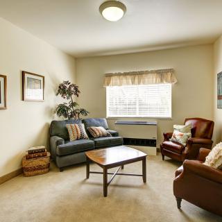 A cozy living room with a couch, two armchairs, and a coffee table.