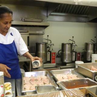 A chef prepares ingredients in a busy kitchen, showcasing the art of food preparation.