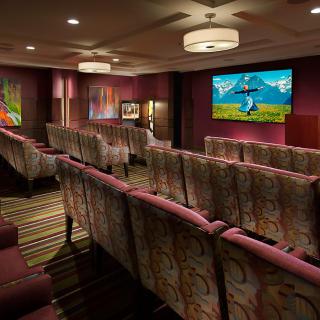 A cozy home theater room with comfortable seating and a projector screen.