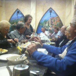 A group of people enjoying a meal together in a restaurant.