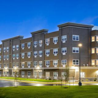 A modern residential apartment building illuminated at night.