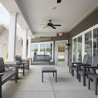 A spacious and inviting covered patio with comfortable outdoor seating and a ceiling fan.