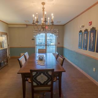A well-decorated dining room featuring a wooden table, upholstered chairs, and a chandelier.