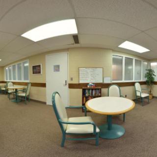 An office waiting area with tables and chairs arranged neatly.