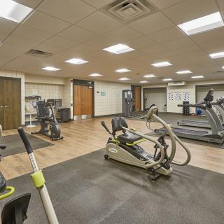 A modern gym with various exercise equipment including treadmills and stationary bikes.