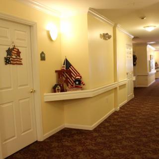 A well-lit hallway with decorated doors and carpeted flooring.