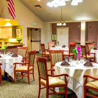 A well-lit dining area with elegantly set tables and comfortable seating.