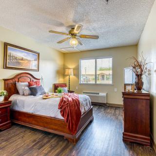A cozy bedroom featuring wood furniture and warm lighting.