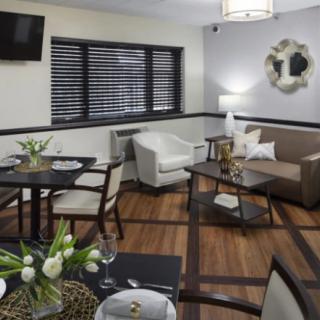 A modern living room with a dining area, featuring sleek furniture and stylish decor.
