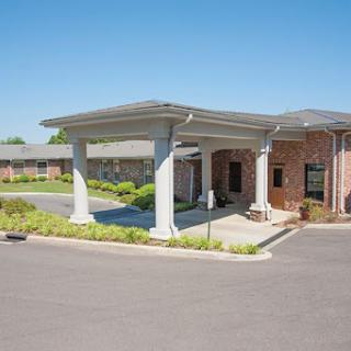 A welcoming entrance to a well-designed facility, featuring elegant columns and landscaped surroundings.