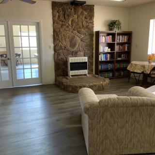 A cozy living room featuring a comfortable sofa, wooden bookshelf, and a decorative fireplace.