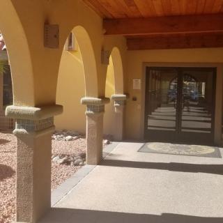 A building entrance with arched columns and a wooden door.