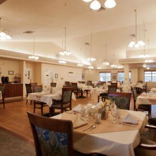 A spacious restaurant dining area with neatly arranged tables and elegant lighting.