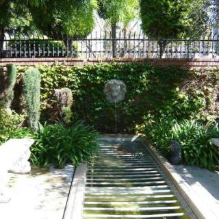 A tranquil garden scene with a water feature surrounded by lush greenery.