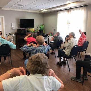 A group of seniors participating in an indoor exercise session.