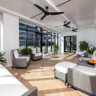 A modern lounge area with ample natural light, featuring comfortable seating and indoor plants.