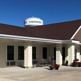 A building with a nearby water tower labeled 'Cherokee' under a clear blue sky.