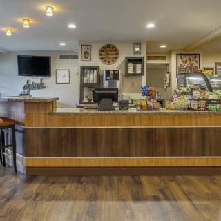 A cozy coffee shop interior featuring a wooden counter, seating area, and an assortment of snacks.
