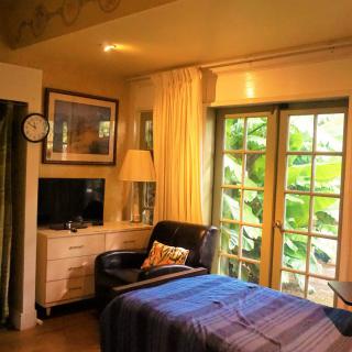 A cozy bedroom interior with natural light streaming through the windows.