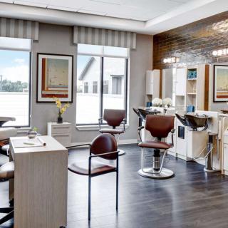 A modern hair salon interior with stylish chairs and mirrors.