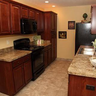 A modern kitchen with wood cabinets and marble countertops.