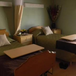 A hospital room with two beds and medical equipment.