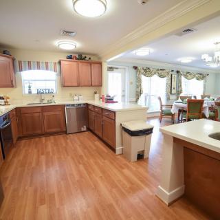 A spacious kitchen with wooden cabinets and an open layout leading to a dining area.