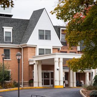 A welcoming entrance of a residential building surrounded by trees.