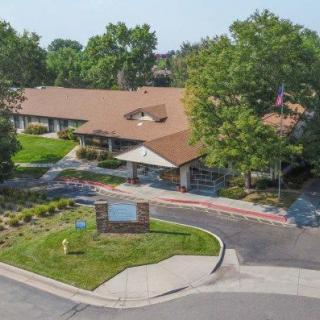 An aerial view of a building surrounded by trees and greenery.