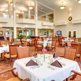 A spacious and elegantly designed dining area with neatly arranged tables and chairs.