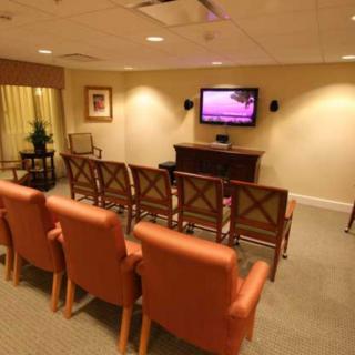 A cozy meeting room with rows of chairs facing a television.