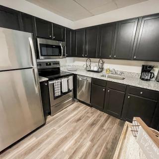A modern kitchen with stainless steel appliances and dark cabinetry.