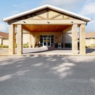 A building entrance with a covered driveway and clear skies.