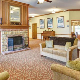 A cozy living room with a stone fireplace, comfortable couches, and elegant decor.