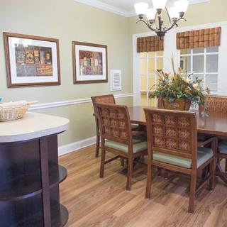 A cozy dining room with wooden furniture, decorative artwork, and elegant lighting.