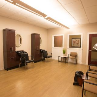 A well-lit and modern waiting area in a hair salon, featuring stylish furniture and a clean design.