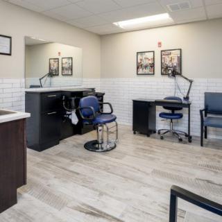 A well-lit, modern hair salon interior with styling chairs and mirrors.