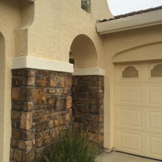 A house exterior with stone accents and a garage.