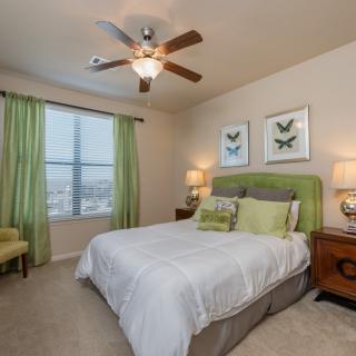 A cozy bedroom with green accents and soft lighting.
