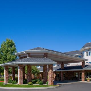 An elegant building entrance with brick columns and a clear blue sky.