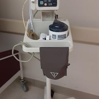 A medical cart equipped with monitoring devices in a hospital environment.