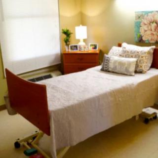 A cozy room with a hospital bed, featuring warm lighting and decorative elements.