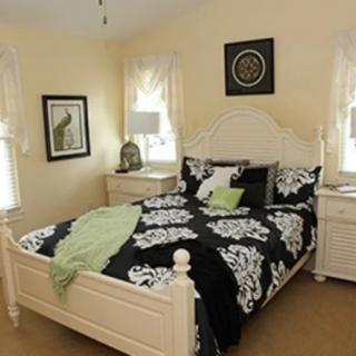 A cozy bedroom with elegant black and white bedding, complemented by light-colored furniture.