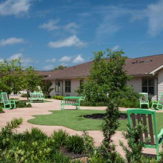 A scenic view of a residential garden with benches and well-maintained landscaping.