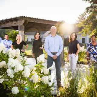 A team gathered in a sunlit garden, captured in a moment of togetherness.